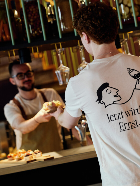 Zwei junge Mitarbeiter des schönen Ernst bei der Arbeit vor uns hinter der Bar. 