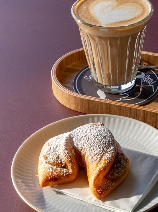 A delicious breakfast at Der schöne Ernst featuring a caffè latte and a nut croissant.