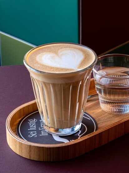 Foamy cappuccino served on a tray at Der schöne Ernst.